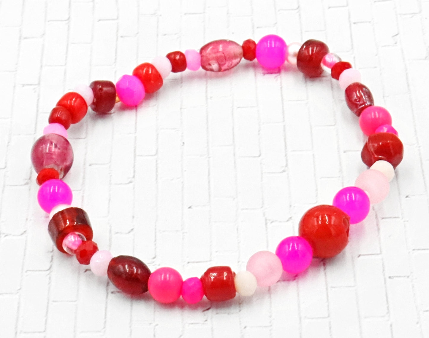 A Bite Out of Our Cherry Hot Pink and Various Red Glass Beaded Bracelet by Monkeys Mojo