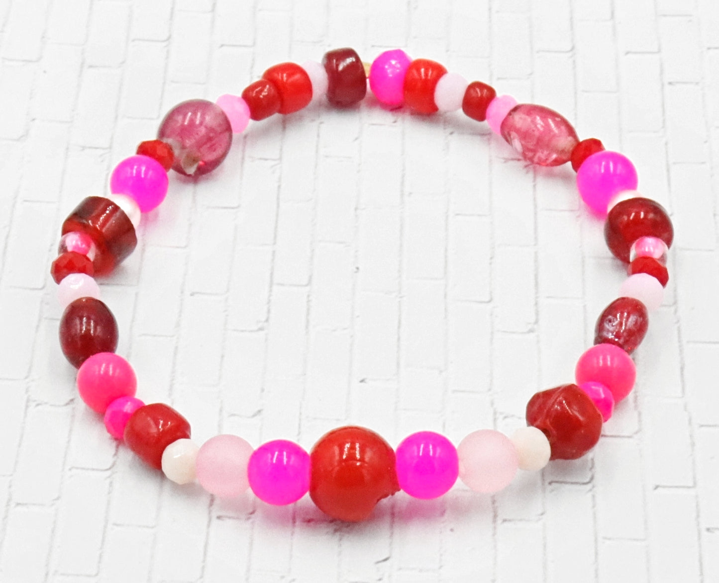 A Bite Out of Our Cherry Hot Pink and Various Red Glass Beaded Bracelet by Monkeys Mojo