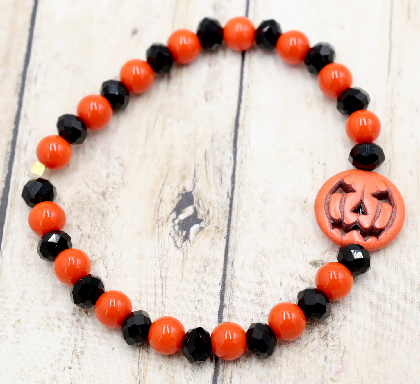 Tricking and Treating Classic Orange and Black Craved Pumpkin Glass Bead Stretch Bracelet by Monkey's Mojo