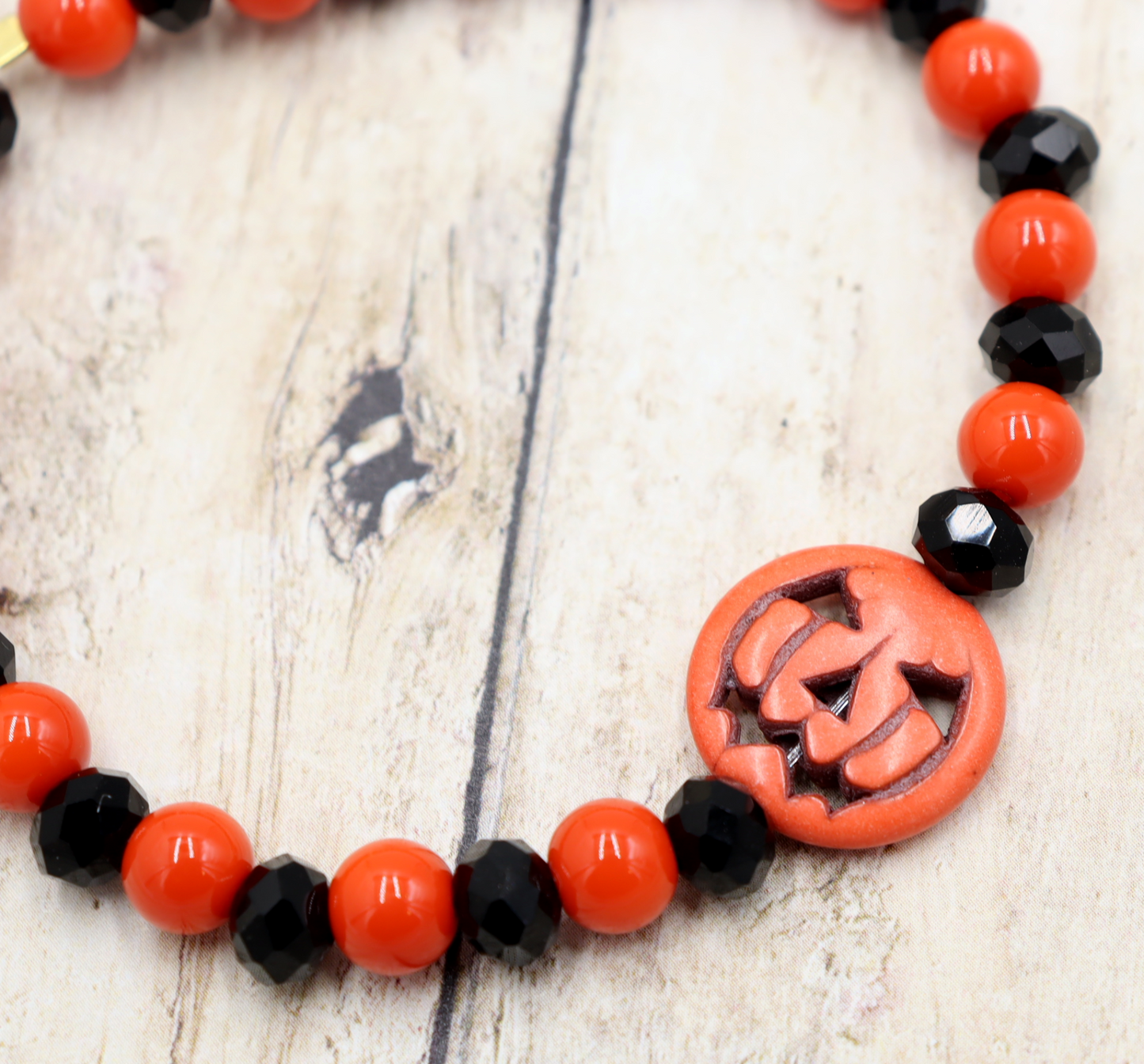 Tricking and Treating Classic Orange and Black Craved Pumpkin Glass Bead Stretch Bracelet by Monkey's Mojo