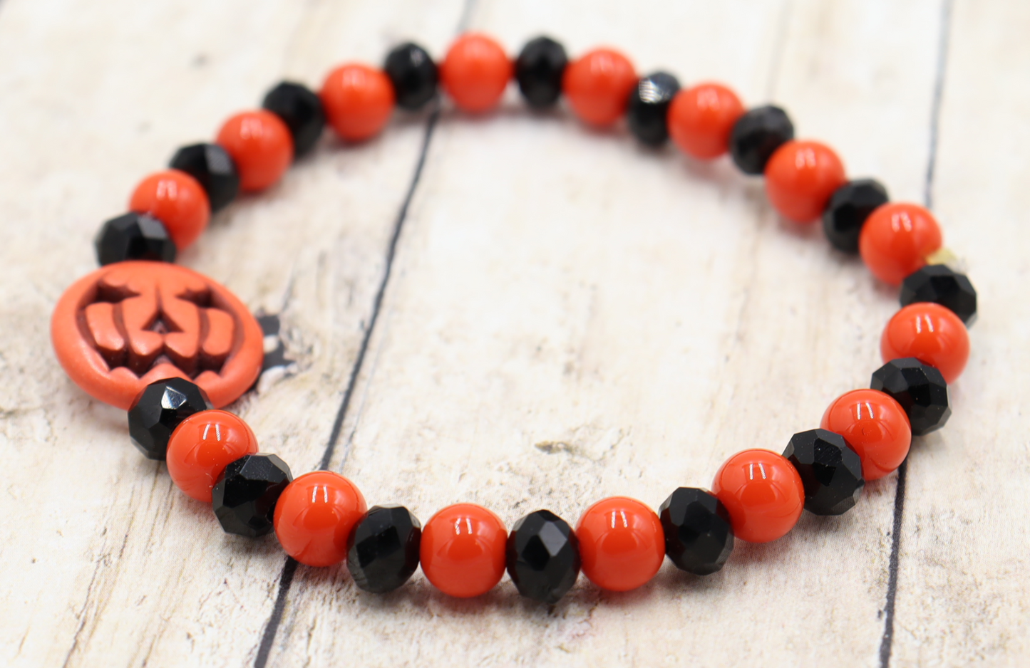 Tricking and Treating Classic Orange and Black Craved Pumpkin Glass Bead Stretch Bracelet by Monkey's Mojo