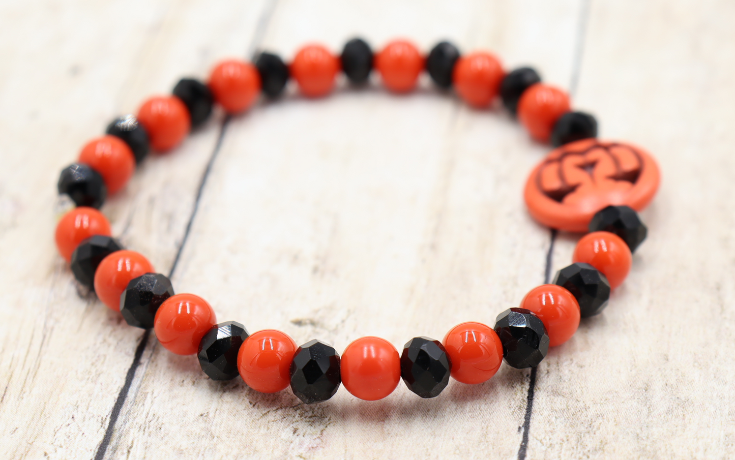 Tricking and Treating Classic Orange and Black Craved Pumpkin Glass Bead Stretch Bracelet by Monkey's Mojo