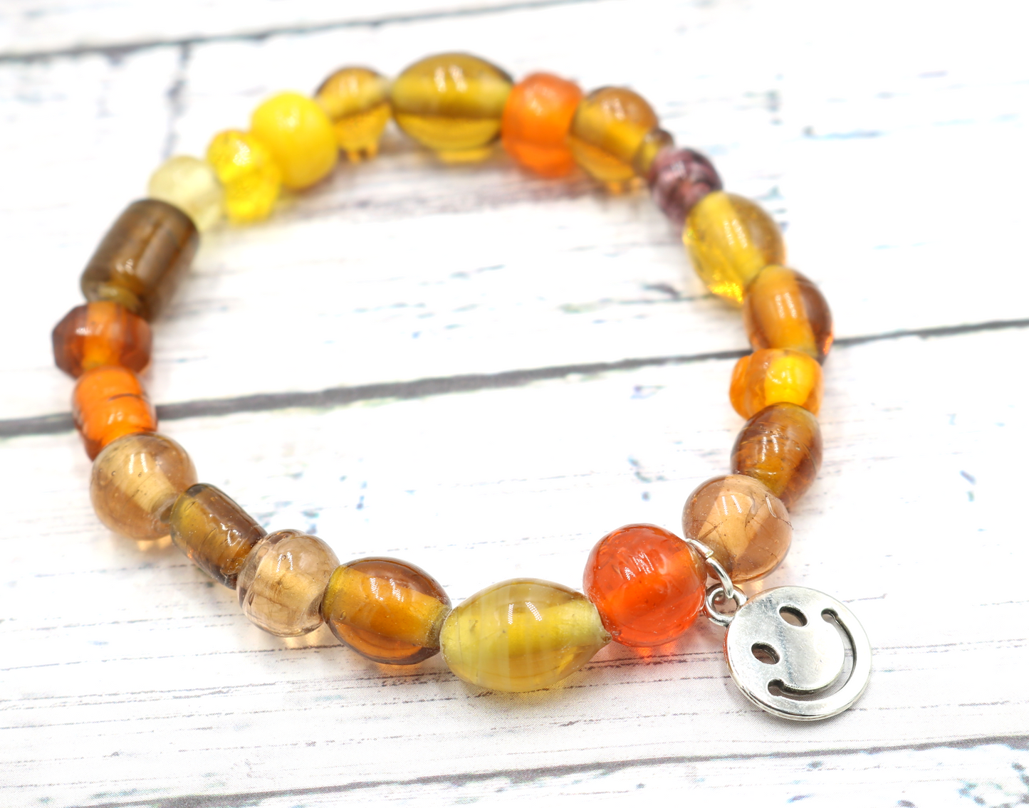 Yellow Hued Warm Artisan Glass Beads Bracelet with Silver Smile Face Charm by Monkey's Mojo