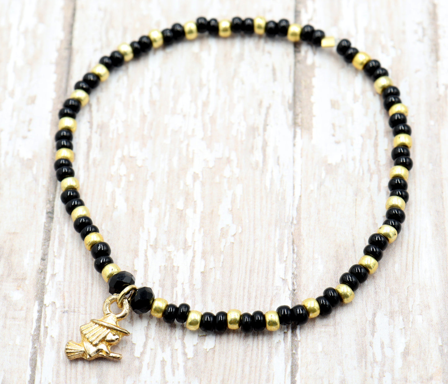 Little Wicked Witch Flying on a Broom Black and Gold Halloween Stretch Bracelet by Monkey's Mojo